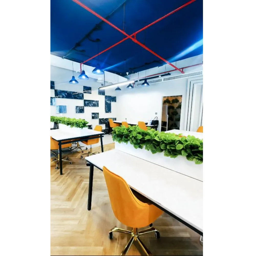 Modern office interior featuring vibrant blue ceiling, decorative green planters, and stylish orange chairs, showcasing a sophisticated design transformation with premium materials.