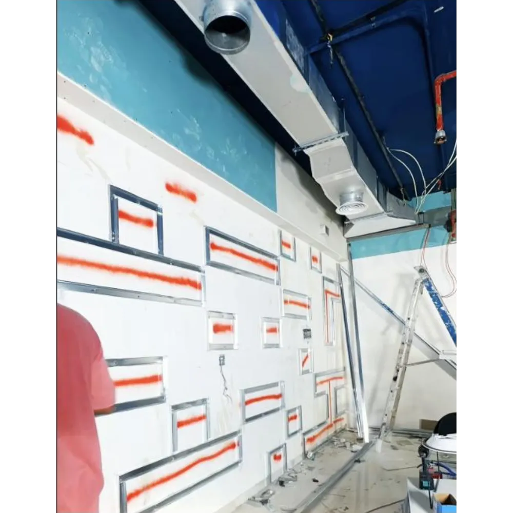 Gypsum partition wall with Arabic accent design elements under construction, featuring metal framing and red markings, showcasing the transformation process in an office renovation project.